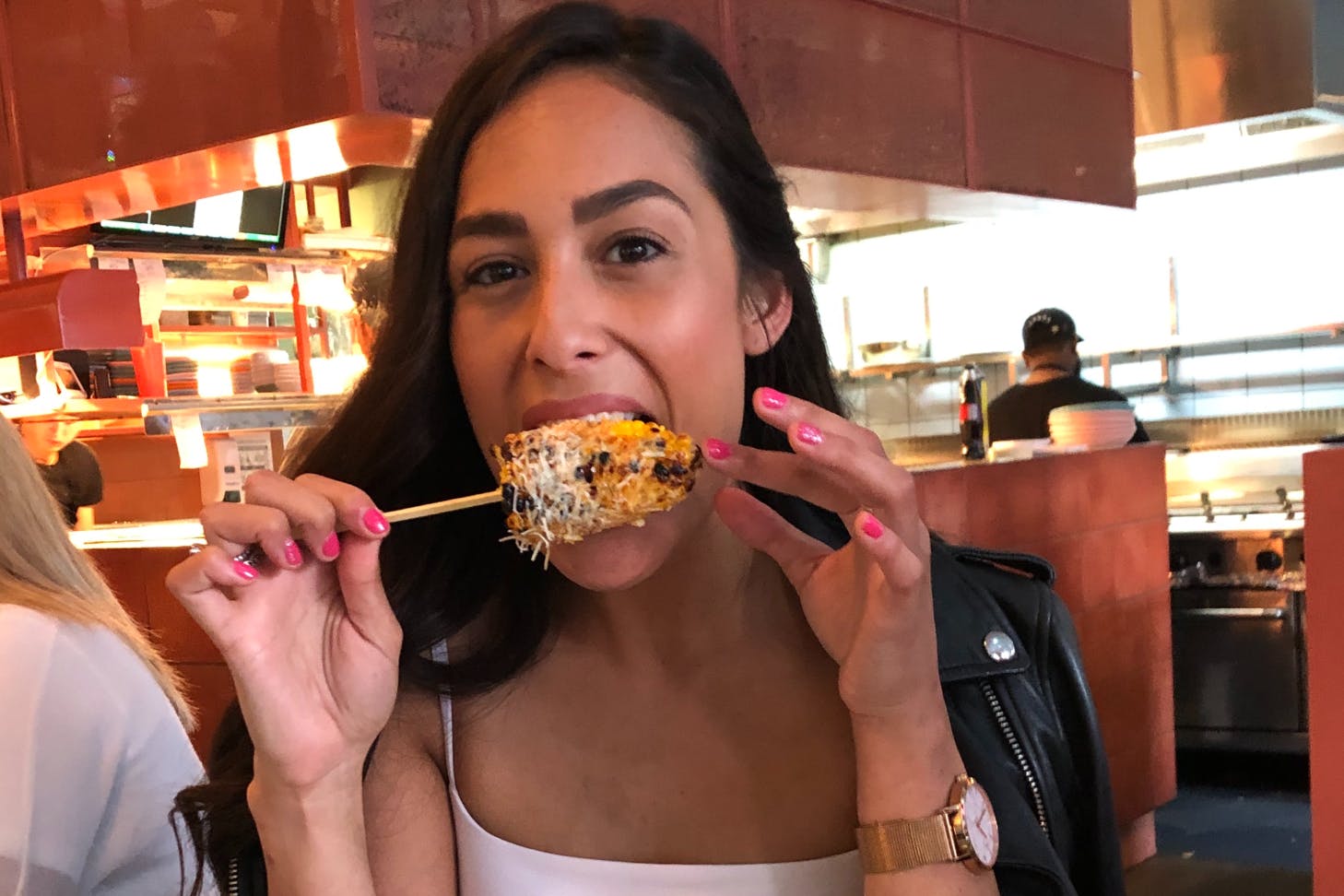 Person eating corn on a skewer